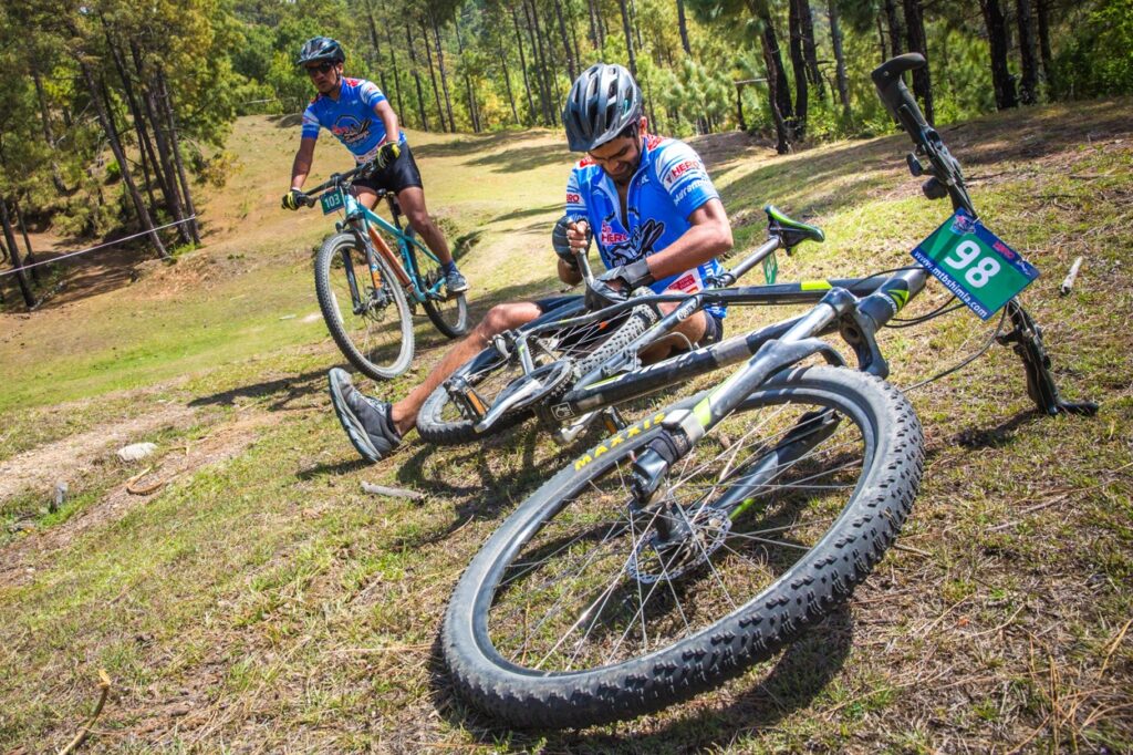 A RIDER FIXES HIS BIKE WHILE ANOTHER TAKES OVER AT MTB SHIMLA 2016 © SWATI CHAUHAN